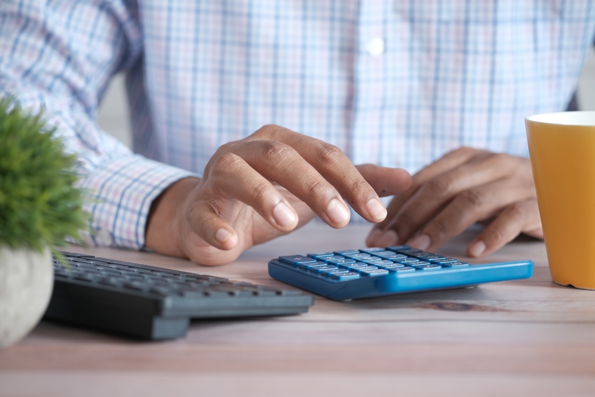 Business owner checking payroll figures with a calculator