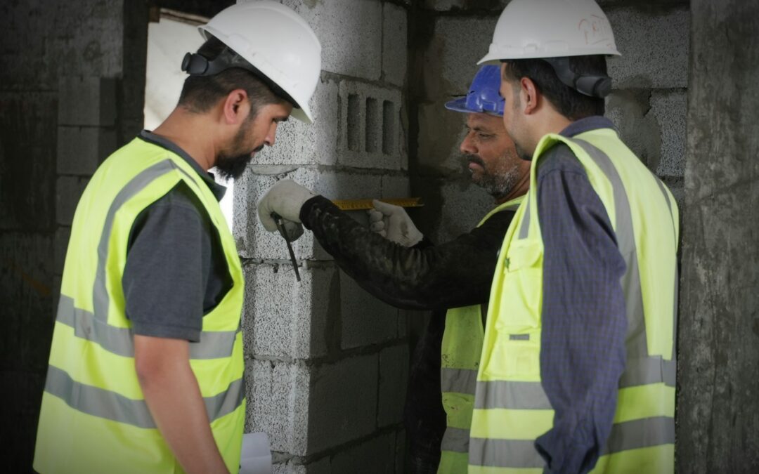 Construction workers in hard hats and hi vis vests on site