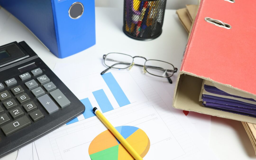 Calculator, charts and folders on a bookkeeping desk